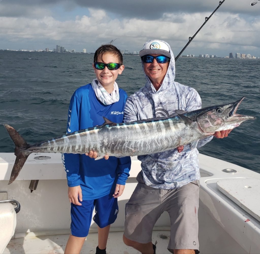 kids holding wahoo fish